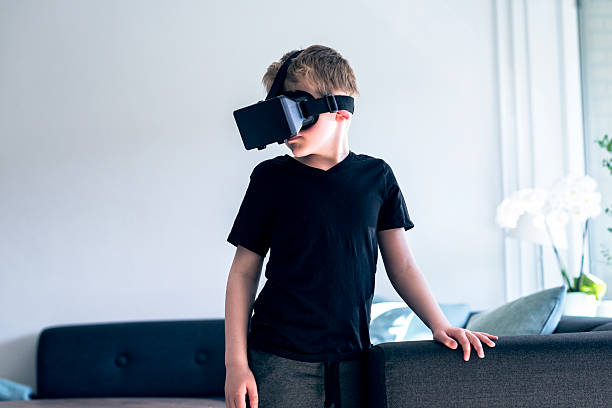 chico usa gafas de realidad virtual en su casa - video game child handheld video game little boys fotografías e imágenes de stock