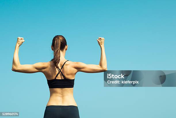 Foto de Retrato De Forte Feminino Flexionando e mais fotos de stock de Mulheres - Mulheres, Só Uma Mulher, Flexionar Músculos