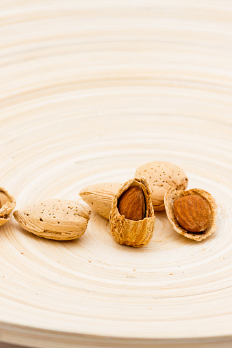 Shelled and unshelled Almond nuts served on a dish