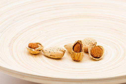 Shelled and unshelled Almond nuts served on a dish