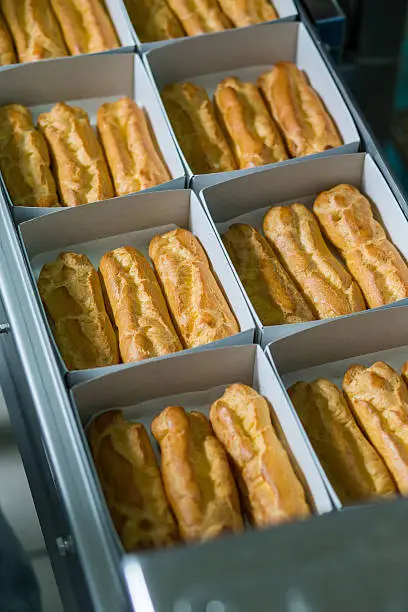 Photo of Eclair boxes on conveyor.