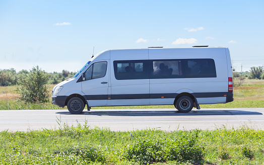 minibus goes on country highway along wood