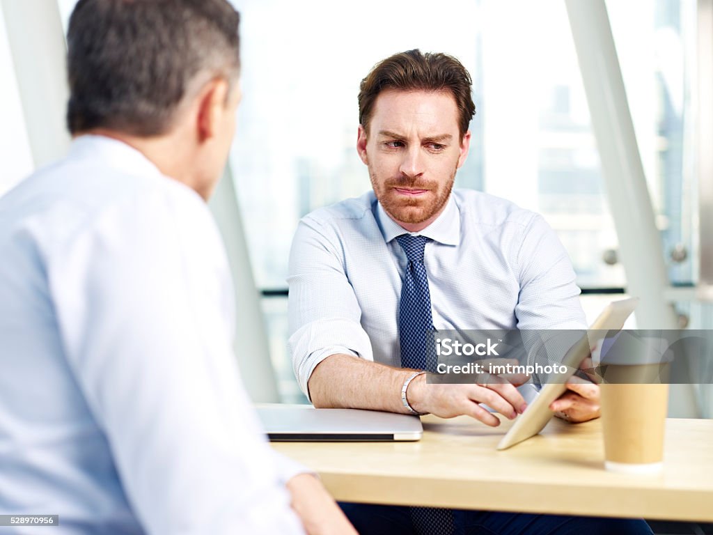 Gente de negocios discutiendo de negocios en la oficina - Foto de stock de Hombres libre de derechos