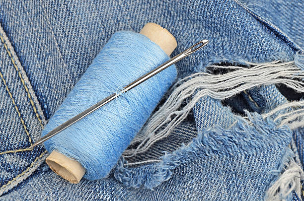 istock Threads on jeans, wear repair concept 528972890