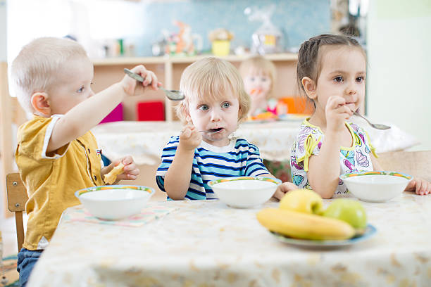 istock Funny kids group eating in kindergarten 528973354