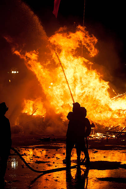 silhouette der feuerwehrleute fighting das entfachte feuer - löschpapier stock-fotos und bilder