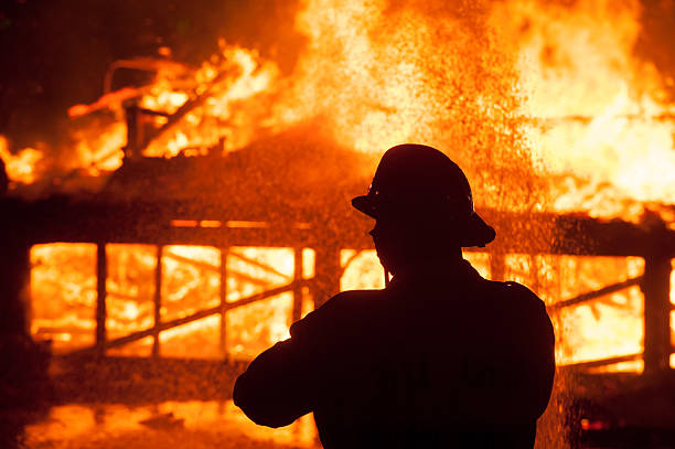 istock Silhouette of Firemen fighting a raging fire 528974416