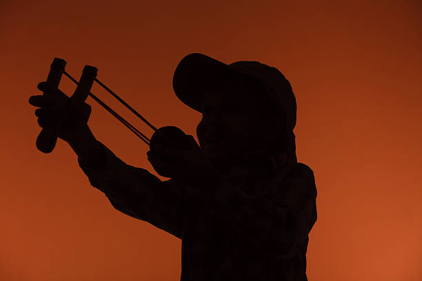 istock Kid holding slingshot in hands 528974418