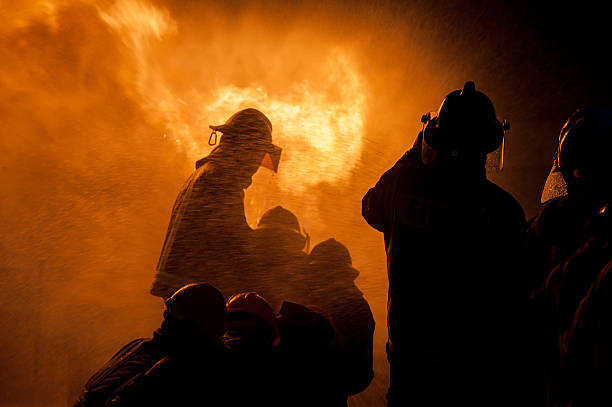 istock Silhouette of Firemen fighting a raging fire 528975398