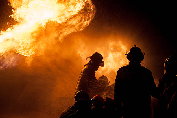 istock Silhouette of Firemen fighting a raging fire 528975446