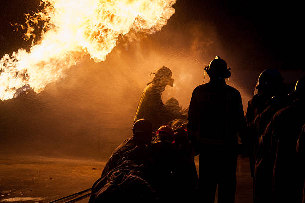 istock Silhouette of Firemen fighting a raging fire 528975472