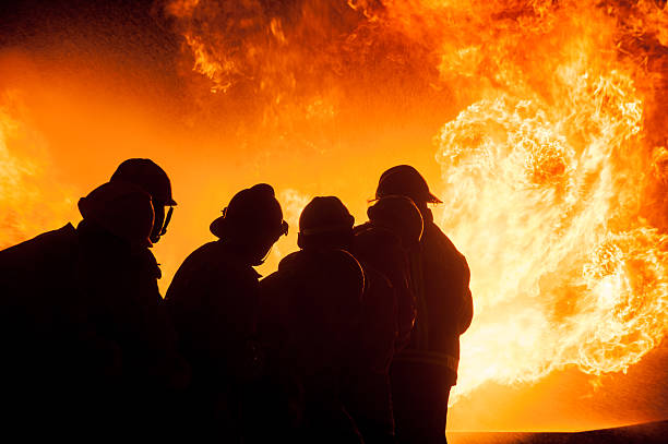 istock Silhouette of Firemen fighting a raging fire 528975540