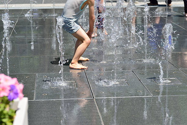 istock Children playing at fountain in a public park 528978020