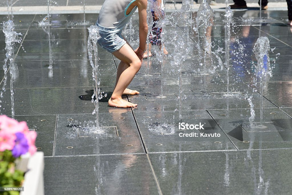 Children playing at fountain in a public park Activity Stock Photo