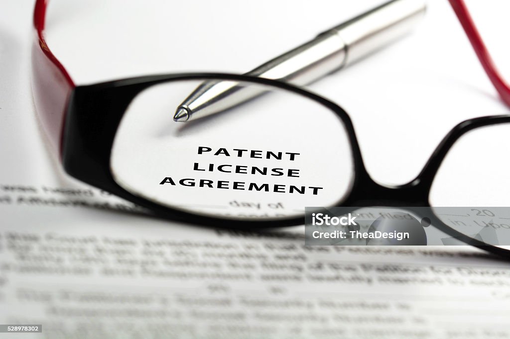 Patent license agreement Patent license agreement through reading glasses. Intellectual Property Stock Photo