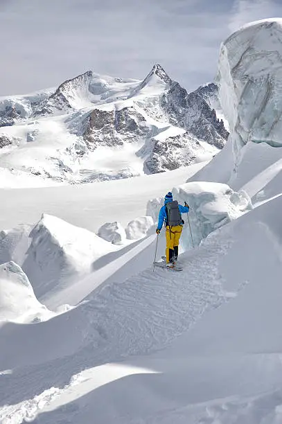 Freerider Guide in the Schwartztor Glacier; in background the highest peaks of Monte Rosa (4664 mt). Zermatt, Swiss, Europe. Exploring and adventure concept.