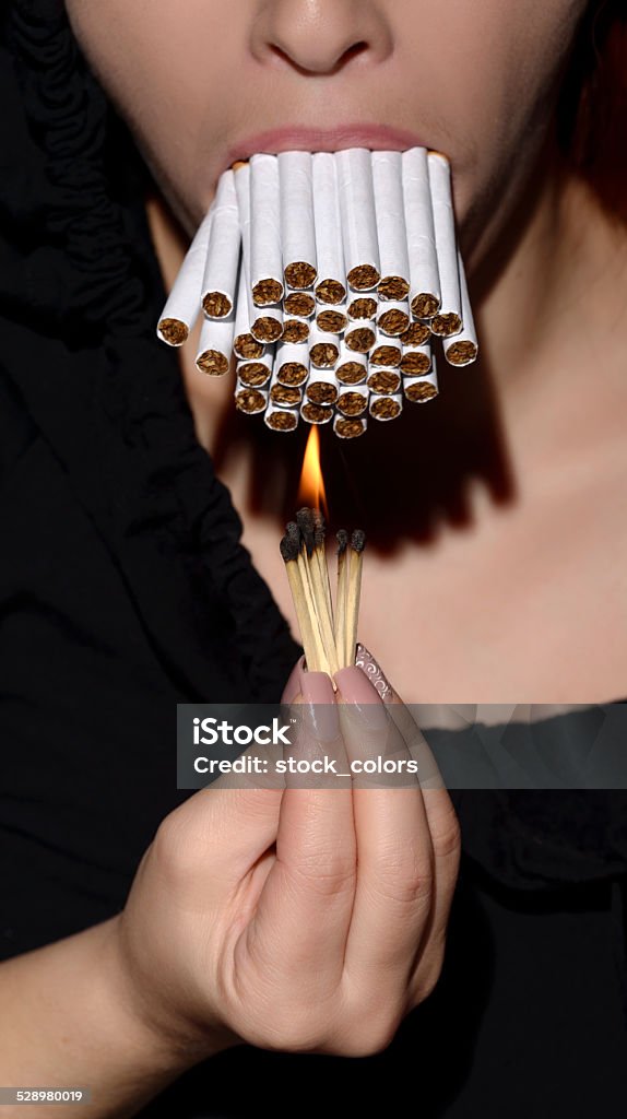 burning cigarettes woman with mouth full of cigarettes burning it. Addiction Stock Photo