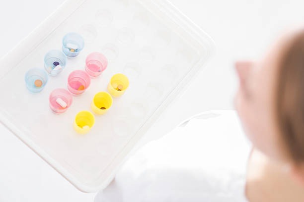 Nurse carrying medication in colorful cups on white tablet