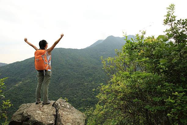 istock cheering woman hiker open arms on mountain peak 528980568