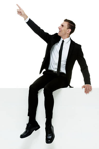 istock Cheerful businessman on box & pointing away 528980749