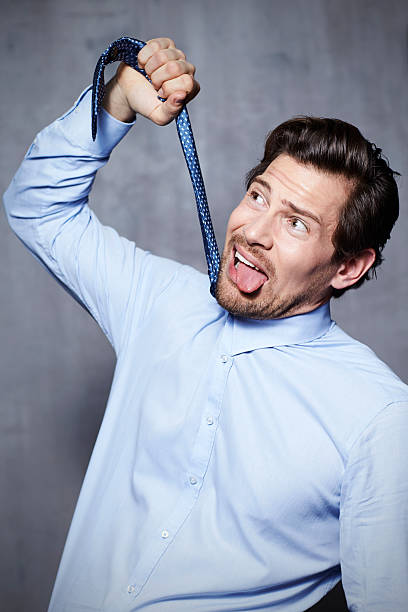 uomo d’affari tirando una cravatta in studio - suicide men business humor foto e immagini stock