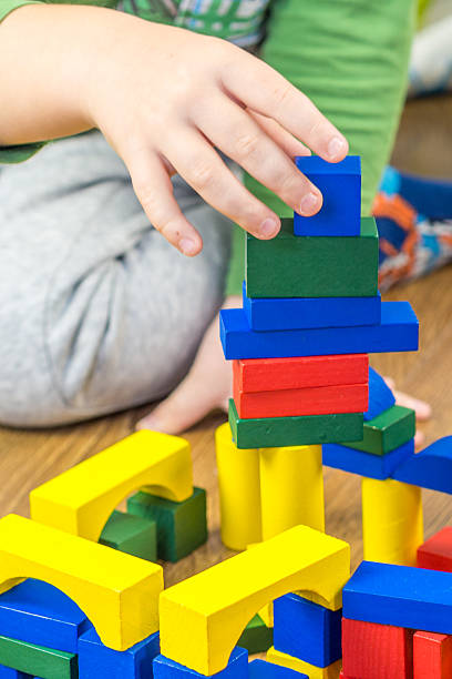 istock child is playing with multicolored cubes on wooden floor 528981561