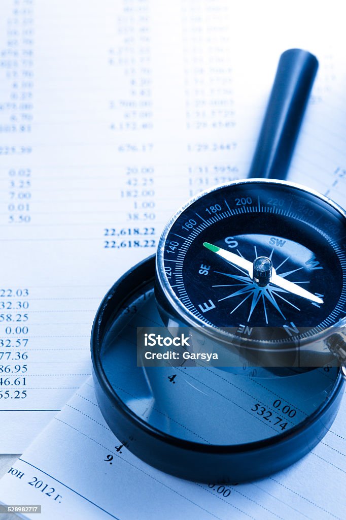 Budget, magnifying glass and compass Budget, magnifying glass and black compass Analyzing Stock Photo