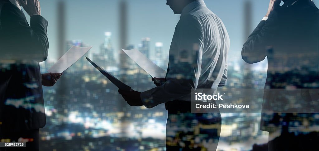 businessman with paper businessman with paper standing in night office Adult Stock Photo