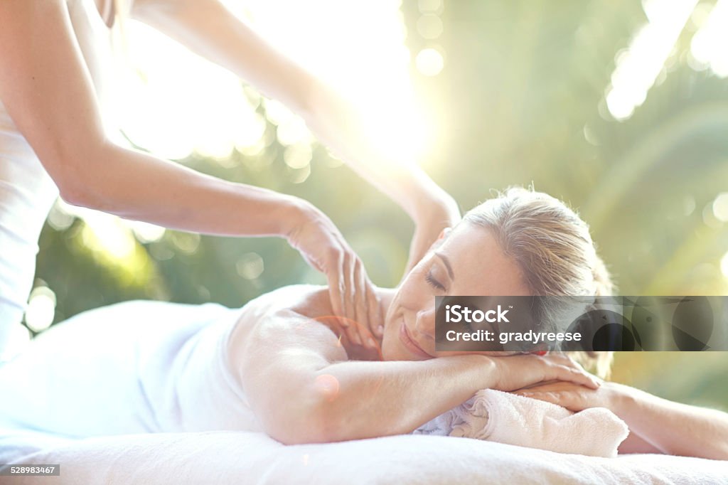 Her stress is melting away Shot of an attractive mature woman enjoying a massage at a day spa 40-44 Years Stock Photo
