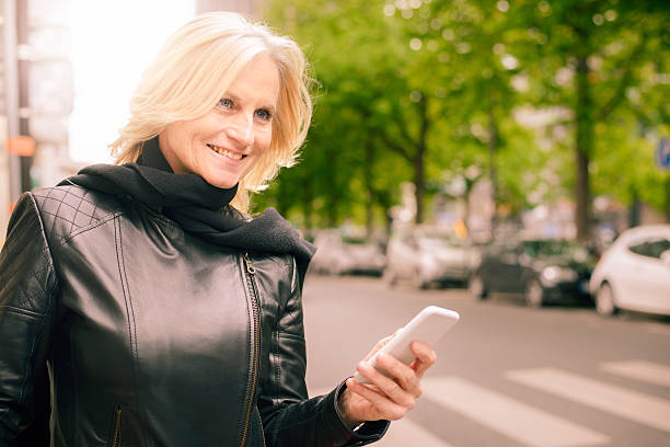istock Mature Woman Using Smartphone App for Taxi Service 528983722