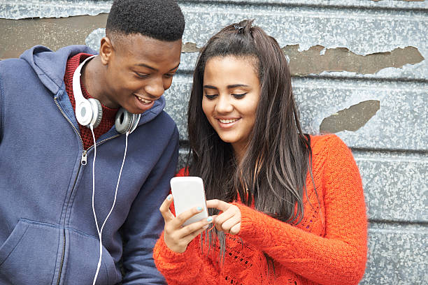 istock Teenager Couple Sharing Text Message On Mobile Phone 528983993