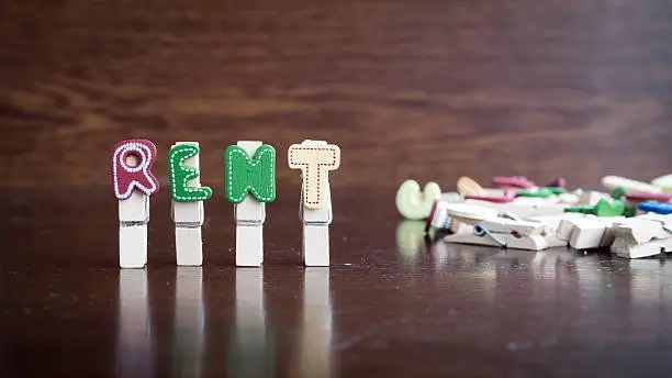 Photo of RENT word on clothes peg stick