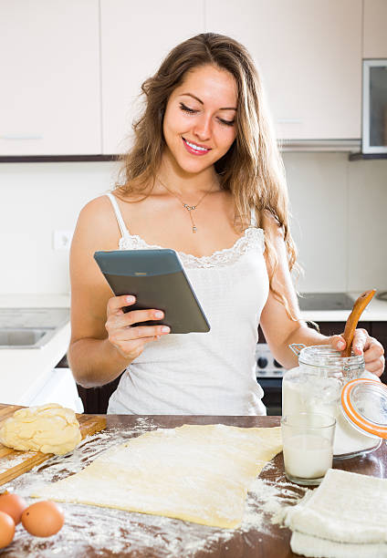istock Housewife cooking with tablet at home 528985021