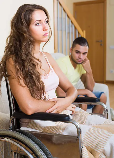 Photo of Sad man with girlfriend in invalid chair