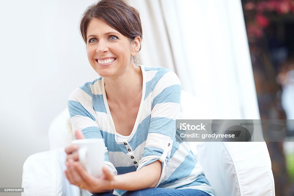 Enjoying life one mug at a time Shot of a beautiful woman enjoying a cup of coffee at home 40-44 Years Stock Photo