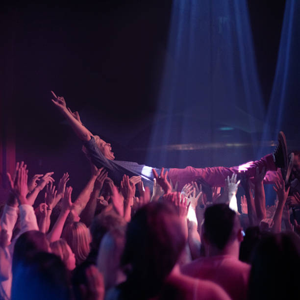 Carried by an amazing crowd! A stage diver being carried across the audience at a rock concert mosh pit stock pictures, royalty-free photos & images