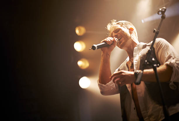 He wrote this one himself Cropped shot of a performer on stage performer stock pictures, royalty-free photos & images