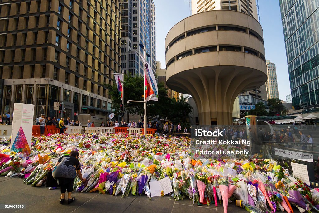 Sydney Siege: Martin Place Memorial Sydney, Australia - December 17, 2014: A woman places a bouquet at an impromptu 'Sydney Siege' memorial, before the MLC tower at Martin Place. The memorial, made up of a mass of bouquets, was created by members of the public a day after two hostages died during a terror attack in a Lindt cafe nearby. City Stock Photo