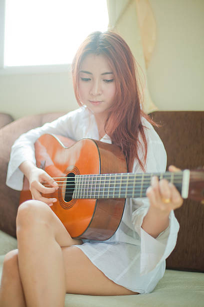 istock Young woman playing guitar 529026177