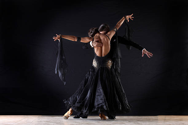 istock Latino dancers in ballroom against on black background 529028083