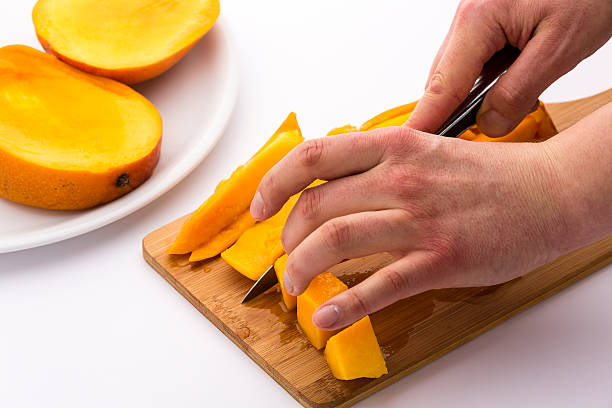 istock Mango Wedges Being Diced On A Wooden Cutting Board 529030757