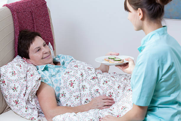 istock Nurse giving patient meal 529049753