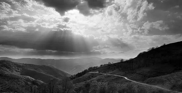 black and white landscape with sunrays over the mountains