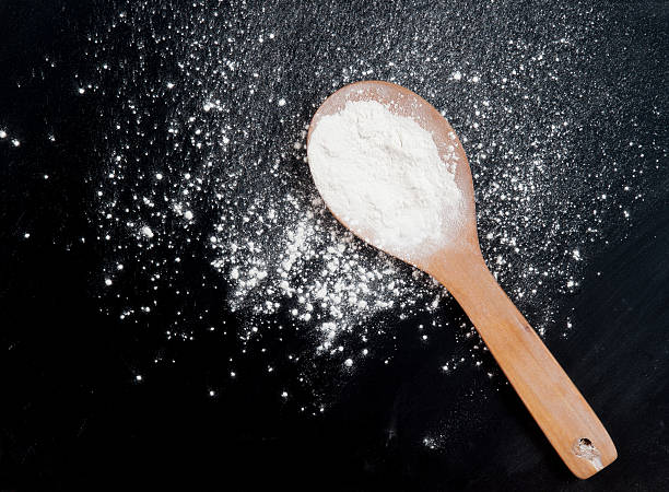 istock White flour with spoon on a black 529054950