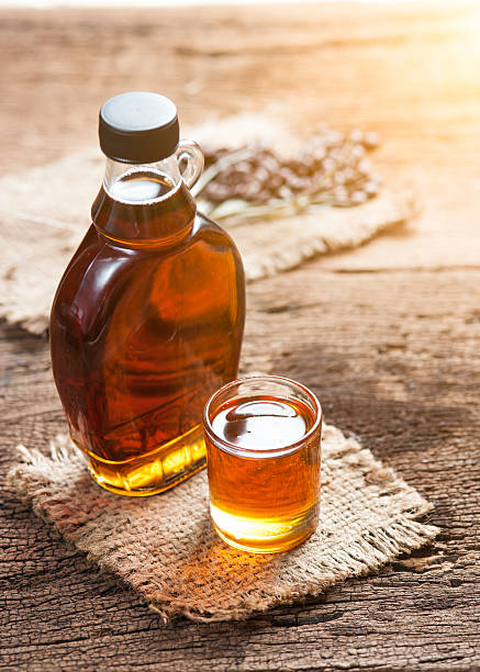 istock maple syrup in glass bottle on wooden table 529055136
