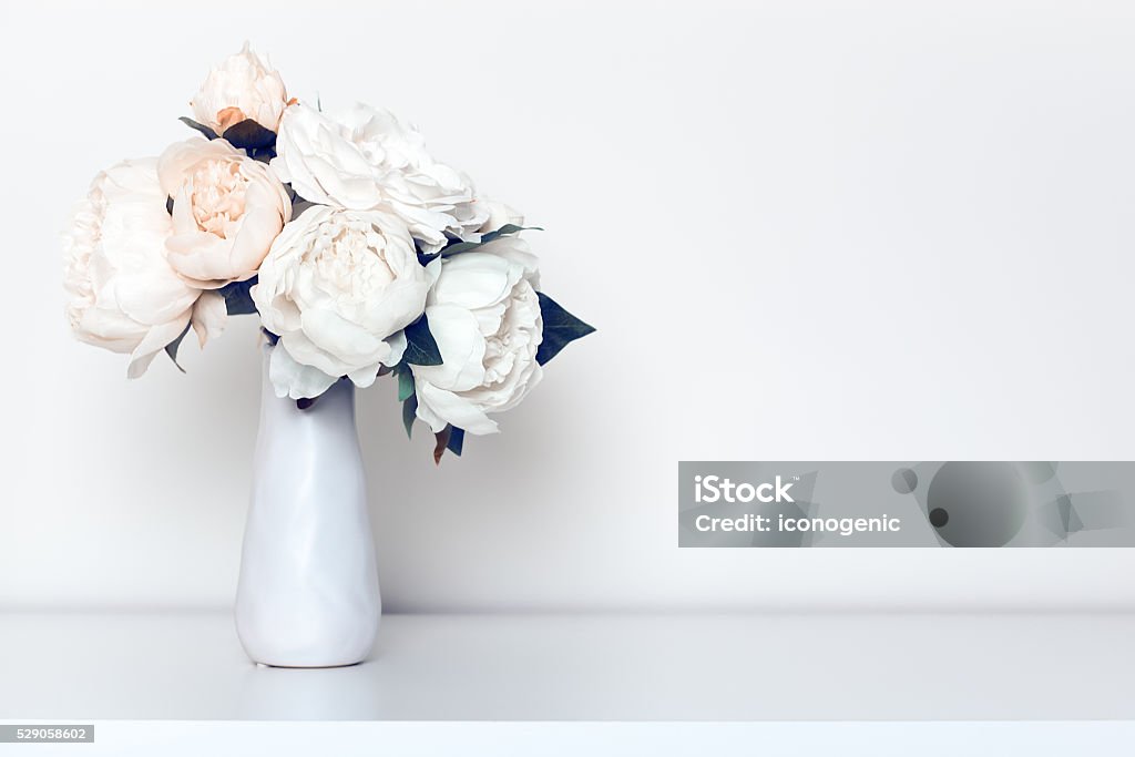 Bleached Peonies In Vase Beautiful peonies bouquet in minimalist indoor setting. Vase Stock Photo