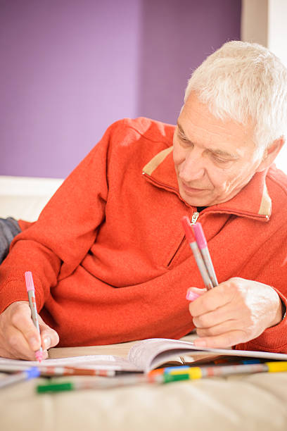 istock Senior Man Relaxing with Adult Colouring Book 529058814