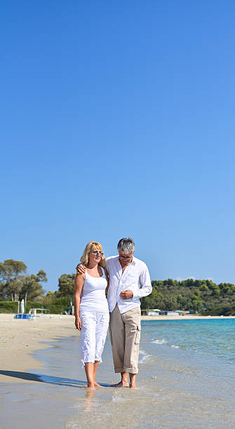 istock Senior couple walking by the sea 529059946