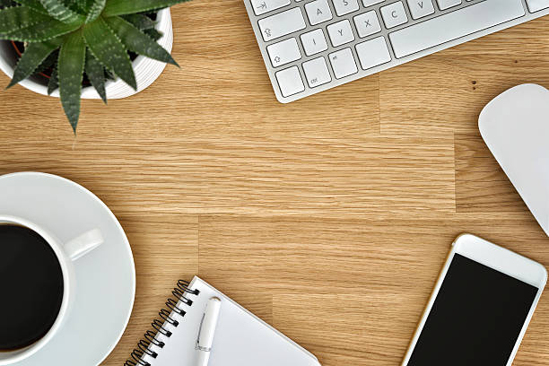 istock Wooden office table with coffee and computer supplies 529064262