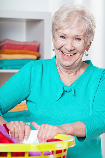 Portrait of smiling elderly woman during housework